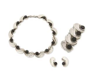 2165
A Group Of Antonio Pineda Mexican Silver And Onyx Jewelry
Antonio Pineda (1919-2009)
Circa 1953-1979; Taxco, Mexico
Each with crown mark for Antonio Pineda; Eagle 17; further variously stamped: Hecho en Mexico / Silver / 970 / Sterling / Mexico / [Design number]
Three works comprising a sterling silver collar necklace of curved wave links set with round onyx (YY439; 15" L x 0.75" H), together with a matching chunky bracelet of larger wave links (ZZ515; 7.25" L x 1.5" H), and a pair of matching earclips (each: 1.25" H), 4 pieces
265.3 grams gross
Estimate: $1,500 - $2,500