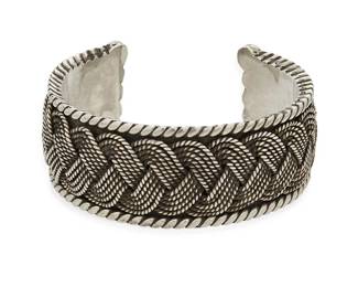 2093
A Hector Aguilar Mexican Silver Cuff Bracelet
Hector Aguilar (1905-1986)
Circa 1940-1945; Taxco, Mexico
Stamped: HA / Taxco / 940
A chunky sterling silver cuff bracelet with braided overlay motif and rope edging
6.75" total inner C x 1.125" H, with a 1.25" gap
111.1 grams
Estimate: $500 - $700