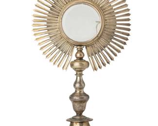 2038
19th century
A Latin American Silver Monstrance
Appears unmarked
The two-piece gilt-washed silver liturgical vessel comprised of a top solar or sunburst section with a central receptacle with circular glass inserts, one piece with a beveled edge, all mounted atop a hammered and repoussé silver base, with further stamped motifs to stem
15" H x 8.5" W x 6.375" Dia.
42.2 gross oz. troy approximately
Estimate: $800 - $1,200
