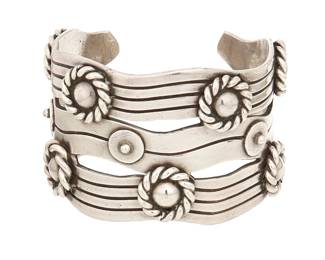 2111
A William Spratling "River Of Life" Silver Cuff Bracelet
William Spratling (1900-1967)
Circa 1940-1944, First Design Period; Taxco, Mexico
Stamped for William Spratling; further stamped: Made in Mexico / Spratling Silver
Designed as incised silver waves with roped Aztec rings
7.25" total inner C x 2" H, with a 1.25" gap
153.6 grams
Estimate: $1,000 - $2,000