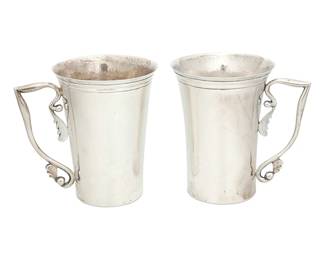 1104
Mid-20th century
A Pair Of Silver Handled Mugs
Each incised to underside: Mir da
The cups with flared rim and foliate form handles, 2 pieces
Each 5.25" H x 5.325" W x 4" Dia.
28.1 oz. troy approximately
Estimate: $400 - $600