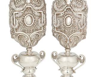 1058
Early/mid-20th century
A Pair Of Mexican Sterling Silver Candle Screens
Each marked to underside: Sterling / Mexico / .925
Each with removeable screens featuring ornately repoussé and chased scrolled, foliate, and garland motifs, set on an urn form body with opposed foliate scroll handles, 4 pieces
Each overall: 17" H x 6.75" W x 4.25" D
69.3 oz. troy approximately
Estimate: $800 - $1,200