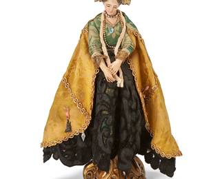 1112
Late 19th/early 20th century, Mexico
A Devotional Madonna Santos Figure
A painted ceramic and plaster Madonna figure, dressed in a gold brocade and green damask cloth mantle and black lace skirt, adorned with a removable gold-toned metal crown, various jewels and milagro charms, with articulated arms and legs, and all mounted to a later-added assembled stand of ornate repoussé gold-toned metal, 2 pieces
16.5" H x 8.5" W x 6" D approximately
Estimate: $300 - $500