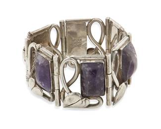 1173
A Fred Davis-Style Mexican Silver And Set Amethyst Link Bracelet
Mid-20th century
Stamped: Mexico / Silver / Mexico
A chunky bracelet with openwork foliate motif links and rectangular set carved amethysts
6.5" L x 1.25" H
118.7 grams gross
Estimate: $400 - $600