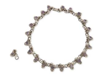 1228
A Fred Davis-Style Mexican Silver And Amethyst Link Necklace
Mid-20th century
Stamped: Silver / Made in Mexico
Comprising a silver "Caviar" trefoil leaf link necklace with set amethyst cabochons, with an extra link, 2 pieces
12.5" L x 0.5" H
58.7 grams gross
Estimate: $300 - $500