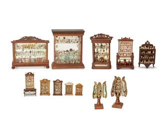 1122
Late 19th/early 20th century
A Group Of Twelve Miniature Cabinets
Comprising two "seed pod" pedestal cabinets with doors and ten miniature dresser display cabinets, all with shelves, in various designs and styles, and each with a multitude of miniature tableware items in various materials including serving items, glasses and goblets, plates, cups, dishes, and other ornaments, 12 pieces
Largest: 12.125" H x 10" W x 3" D; Smallest: 3.5" H x 2" W x 0.75" D
Estimate: $600 - $800