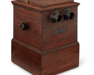 1274
Circa 1860
An Alexander Becker Stereoscope Viewer
Marked to metal plaque: A. Becker's Patent / Jas. [James] Lee N.Y. Manufacturer / April 7 1857
The stereoscope with double-sided viewing in a wood casket with hinged light window and side handles to advance the stereo cards
14.5" H x 9.325" W x 12" D
Estimate: $800 - $1,200