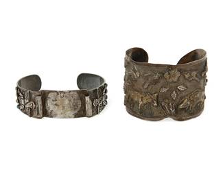 1328
Two Silver-Toned Metal Cuff Bracelets
Early/mid-20th century
Each appears unmarked
Comprising a silver toned metal cuff with rustic floral and fauna overlay motifs including a boar and donkey (6.75" total inner C x 1.75" H, with a 1" gap), and a Southwest-style silver metal and set stone watch cuff with various overlay motifs including arrows, thunderbird figures and sunface (7" total inner C x 0.875" H, with a 1.125" gap), 2 pieces
90.3 grams
Estimate: $300 - $500