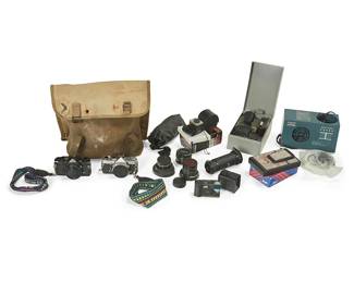 1307
Circa 1970s
Two Olympus OM-1 35mm Cameras And Assorted Accessories
Each marked: Olympus / OM-1; MADE IN JAPAN
Comprising two Olympus SLR cameras (serial numbers 292355 and 441910) with various flashes and lenses including a 75-150mm, three light meters including a Weston Master II, and a film drying machine, sold together with a Mamiya-16 Automatic 16mm subminiature viewfinder camera and a Polaroid SX-70 Land Camera Model 3 with a pack of film, all housed in Dr. Amy Conger's photo satchel, personalized with glitter puff paint
Olympus: 3.325" H x 5.5" W x 2.25; satchel: 11" H x 14" W x 8" D approx.
Estimate: $300 - $500