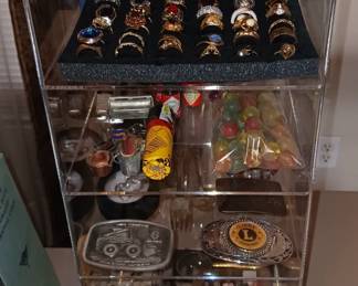 Lots of Rings, Pocket Knives, 3 Belt Buckles, Danbury Mint Bracelet, Bag of Old Marbles, Tiny Tabasco Bottles, Old Gillette Razor and a Tube of BB's, Also Mickey Mouse Watches on top of the case.