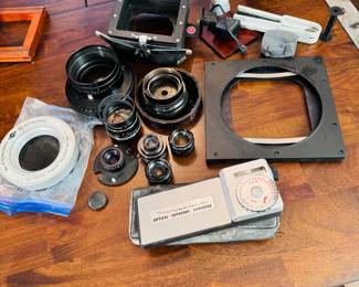 Group of vintage photography equipment including optical exposure computer, lenses and shutters 