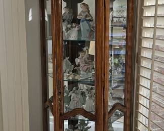 Maple corner cabinet filled with LLadro. Some with boxes.
