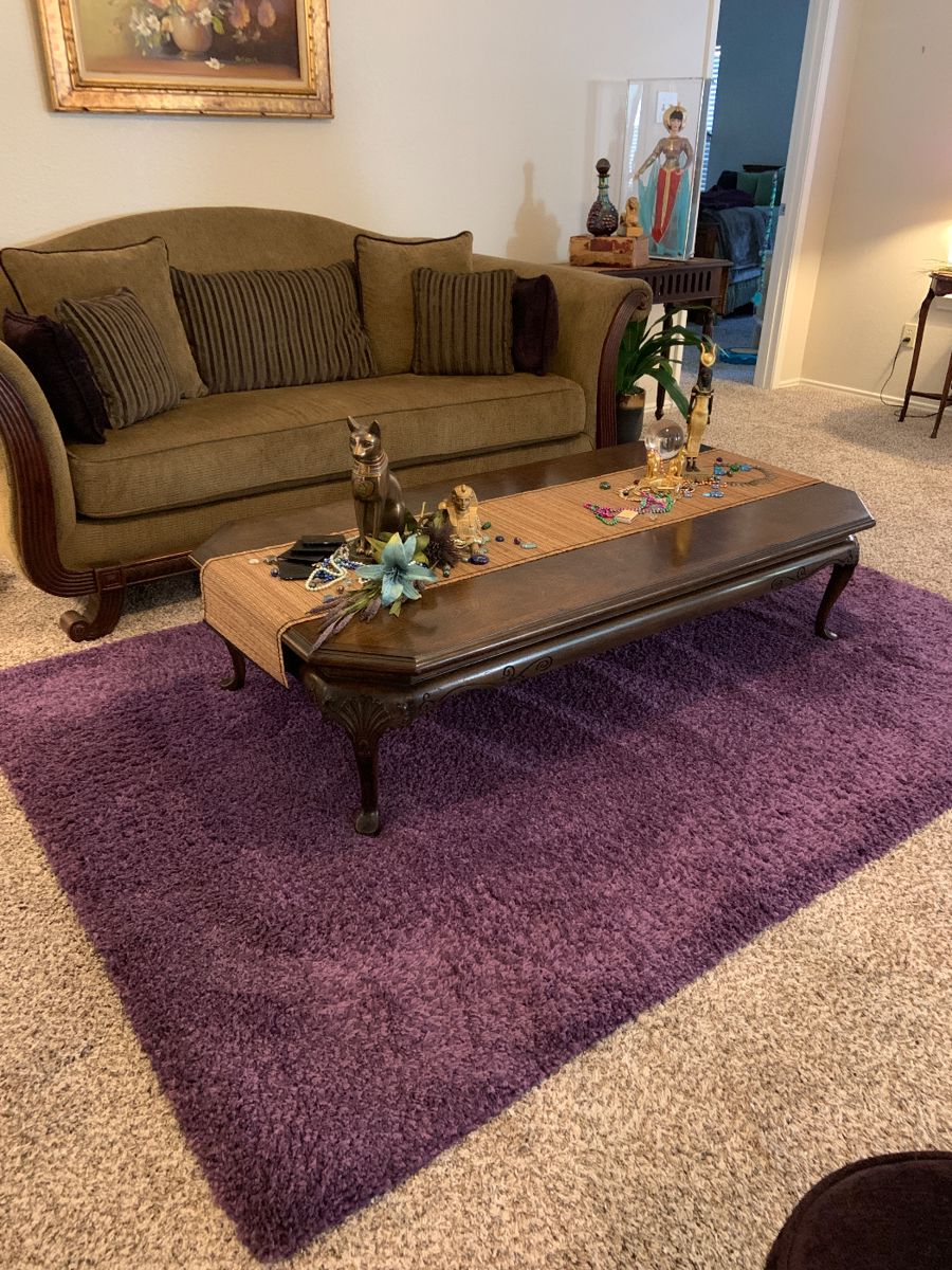 camel back sofa with custom made pillows, coffee table, and purple accent rug