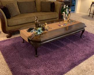 camel back sofa with custom made pillows, coffee table, and purple accent rug