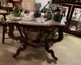 This marble-topped decorative table has several jars sitting on top of it.  Come check it out!