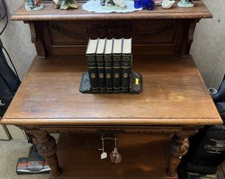 This side table also shows a five-volume Mark Twain collection of stories, along with a few ceramic figurines on the top shelf.