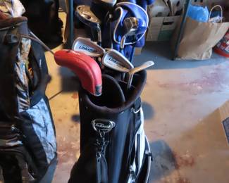 Three sets of golf clubs.