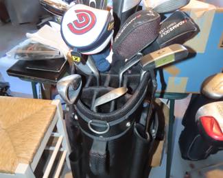 Three sets of golf clubs.