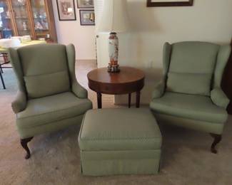 Two matching wingback chairs and a footstool.