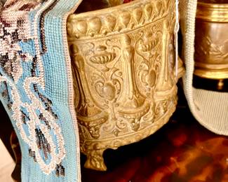 ANTIQUE FRENCH CACHEPOT WITH ANTIQUE AND VINTAGE TEXTILES ON TORTOISE SMALL TABLE.