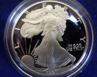 Lot 48. One 1991 encapsulated American Silver Eagle coin containing 1 troy oz. of 99.9% silver with a COA in a&nbsp; velvet display case