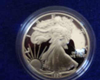 Lot 49. One 1990 encapsulated American Silver Eagle coin containing 1 troy oz. of 99.9% silver with a COA in a&nbsp; velvet display case