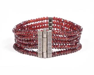 GARNET FACETED BEAD & MIXED METAL BRACELET | Having five strings of garnets on a chased engraved antique silver clasp