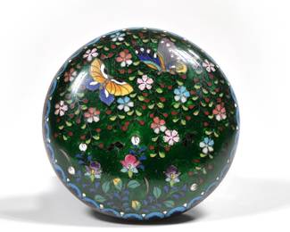 CHINESE CLOISONNE BOX | Small round lidded box with cloisonne decoration of butterflies among flowers on a green ground; dia. 3.75 in.
