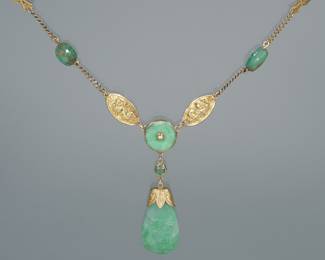 CHINESE JADE & 14K GOLD DROP NECKLACE | Designed as an early 14k gold chain with 2 stations of jade beads, 2 stations of chased gold plaques with flowerheads, 2 stations of carved jade scarabs, 2 stations of chased gold plaques with dragons, centering a gold mounted bi disc suspending a jade cabochon and a carved teardrop form jade pendant (1.5 in.) 25 in., 31.0g
