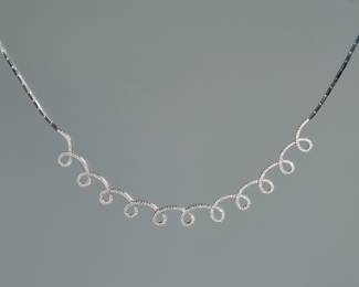 DIAMOND & 18K WHITE GOLD SPIRAL LINE NECKLACE | having eleven articulating loops mounting a continuous line of melee diamonds set in 18k white gold, box clasp with two security latches; marked "750". total weight 18.6g, l. 15 in. (approx.)
