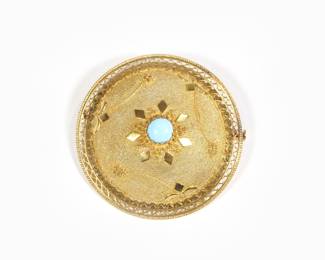 18K GOLD & TURQUOISE BROOCH | Round pin having a central round evenly colored turquoise cabochon in a textured 18k gold dome surround with applied decorations with an openwork border, marked "K18";  16.4g, dia. 1.75 in.
