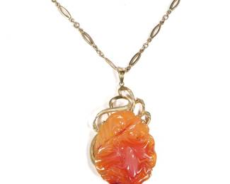 CHINESE AGATE CARVED FROG PENDANT NECKLACE ON GOLD CHAIN | Designed as a finely carved frog upon a leaf beside a flower, the reverse carved in complement, mounted in an openwork 14k gold surround (h. 2 x w. 1.625 in., 32.7g, pendant )and suspended from a 14k gold chain (27 in., 19.6g, chain).  together 52.3g

