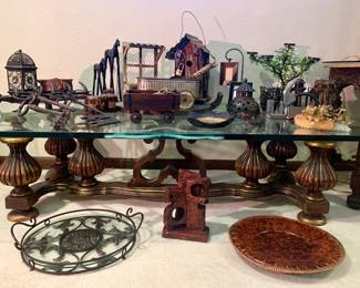 Signed glass coffee table topped with cast iron and metal decor