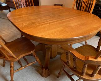 Amish oak claw foot pedestal table with two captain chairs, two side chairs and one leaf