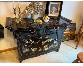 Oriental black lacquer side table with carved inlaid design.