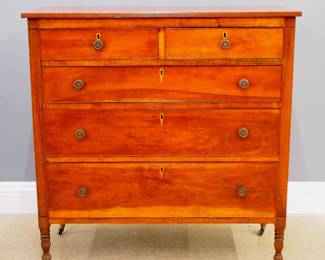 A 19th American Country Sheraton chest.  Cherry construction with figured Maple drawer blades features two short over three long dovetailed drawers with cock beaded edges, reeded detail on top and stiles, tall turned legs with fluted carving.  Older refinishing with minor wear, top re-attached, lacks some drawer locks.  19 x 44 x 45" high overall.