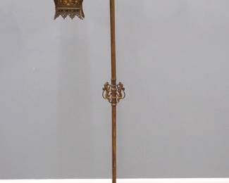 An early 20th century Gothic Revival Period reading floor lamp by Brady Lite, Detroit.  Patinated Iron construction with Sword/Coat of Arms form bridge and pierced lantern shade with Mica liners and hinged side fitted with a magnifying lens, on a hammered stem and cast foot.  Retains original "Brady Lite Magnifier, Detroit, Pats. Pend." label by lens.  Wear to patina, small losses to Mica.  62 1/2" high.