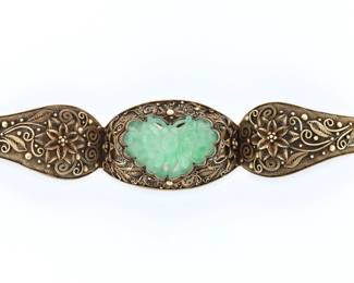 An early 20th century Chinese Jade and Silver filigree bracelet.  Scrolling floral filigree design with central carved Jade butterfly and Gilded finish.  Impressed "Silver" at clasp.  Some wear to Gilded finish.  6 1/4" long open.