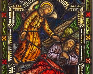 A Gothic Revival stained glass panel of Joseph's Dream.  Multi-color stained and leaded glass panels with reverse painted detail depicting an Angel appearing to Joseph in a dream within geometric and foliate borders.  Two panels cracked at Angel's robe, some wear to paint.  18 1/4 x 29 1/2" high overall.