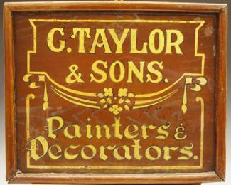 A turn of the century window glass Trade Sign advertising "G. Taylor + Sons, Painters and Decoraters".   Single sided sign with reverse painted on glass with Gold lettering on a Grain painted background.  Some wear, in an older wooden frame.  Frame is 20 3/4 x 17" high overall.
