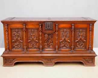 A 19th century Gothic Revival Period carved Oak armory chest.  Carved lift top over a central figural panel flanked by four carved tracery panels with animal figures and carved pilasters, Iron hinges and Cathedral lock, on a bracket base with carved mythological figures.  Older finish with minor wear, minor damage and repairs.  69 x 21 x 35" high overall.