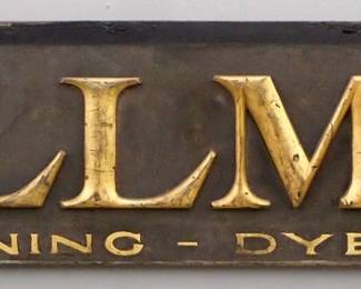 A turn of the century wooden Trade Sign advertising "Wollman, Cleaning - Dyeing".   Single sided painted wooden sign with applied and painted Gold lettering on a Blue schmaltz background.  Some surface wear, outer edge repainted.  79 1/4" long x 14 1/2" high overall.