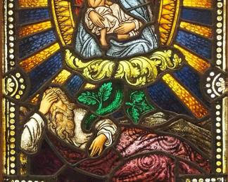 A Gothic Revival stained glass window of Joseph's Dream.  Multi-color stained and leaded glass panels with reverse painted detail depicting the dream which revealed to Joseph that Mary was carrying the Son of God, within geometric and foliate borders.  Soldered restoration and crack to Mother and Child panel, some wear to paint.  In a later Oak frame, 20 1/2 x 32 3/4" high overall.