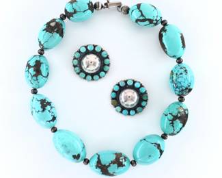 Federico Jimenez, Mixtec, b. 1941.  Three pieces of late 20th century Turquoise and Sterling Silver jewelry.  Includes a necklace with large oval turquoise stones strung on a Sterling cord with Sterling spacer beads, and a pair of clip on earrings with central Sterling hemispheres surrounded by twelve Turquoise cabochons.  Each marked "JF" and "Sterling" at clasps.  Minor surface wear.  Necklace is 17" long open, earrings are 1 1/4" high.