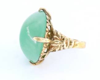 An early 20th century Chinese Jade ring.  Oval cabochon Jade stone prong set on Gold Filled ring with pierced lotus design.  Incised "MG".  Minor surface wear to ring and stone.  Size 6 1/2.