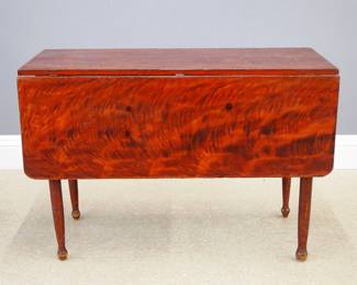 A 19th century American painted drop leaf table.  Pine construction with drop leaves and simple turned legs.  Original Red/Yellow grain painted finish.  Some surface wear and older repair, legs loose.  19 x 17 (42" open x 28 1/2" high overall.