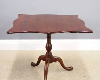 An early 19th century American tilt-top tea table.  Cherry construction with shaped top on a turned baluster standard with three cabriole legs and pad feet.  Older finish with wear and minor repair.  35 x 34 x 28" high overall.