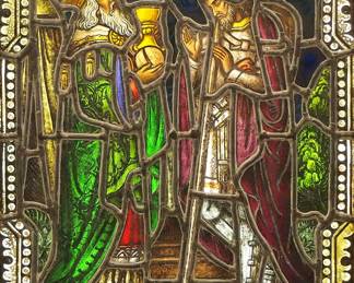 A Gothic Revival stained glass window of Melchizedek and Abraham.  Multi-color stained and leaded glass panels with reverse painted detail depicting King Melchizedek of Salem bringing bread and wine to Abraham within geometric and foliate borders.  Panels intact, some wear to paint.  In a later Oak frame, 20 1/4 x 29 1/2" high overall.