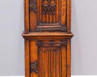 A turn of the century Gothic Revival Period carved Oak side cupboard.  Molded top over one central door with carved tracery, flanked by rope twist columns, over a lower door with linen fold carved panel, Iron hinges and lock.  Original finish with some wear, minor shrinkage, a few marks to top.  19 1/2 x 13 1/2 x 52" high overall.