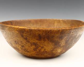A 19th century American Burl Maple bowl.  Turned round form with folded rim and carved band detail.  Some wear and discoloration to finish.  18" diameter x 7" high overall.